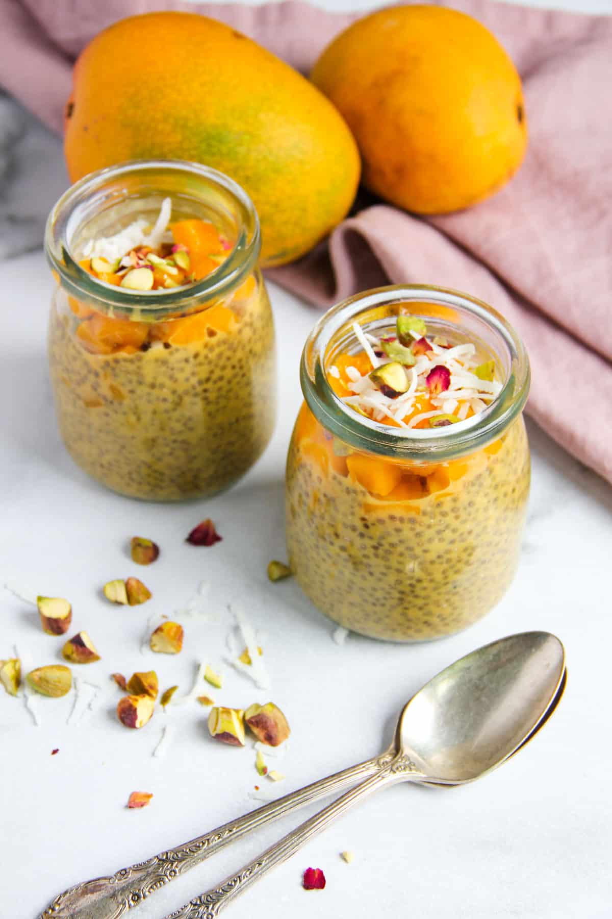 mango chia pudding served in two glass jars 