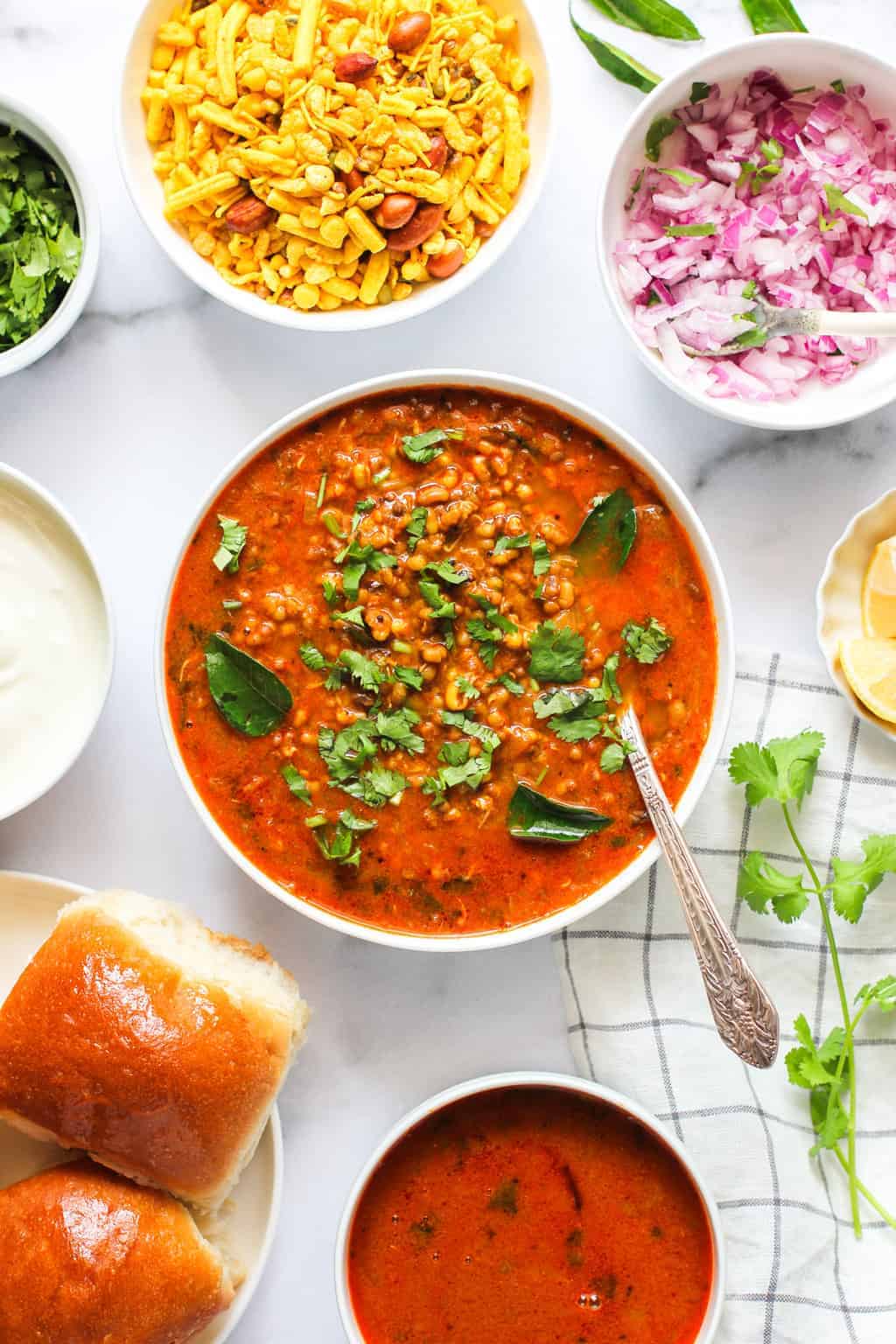 Misal Curry served in a big bowl with all the condiments on the side