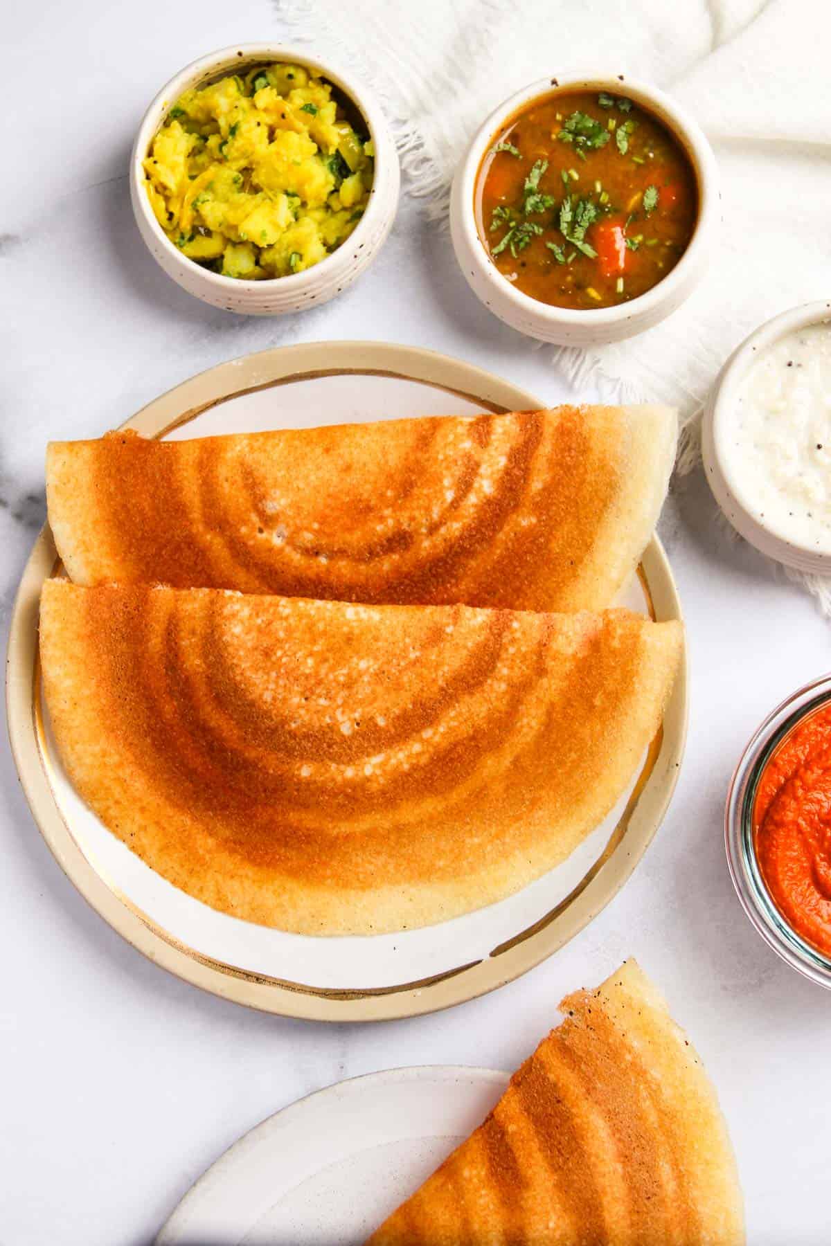 Dosa served with chutney, sambar and spicy potatoes