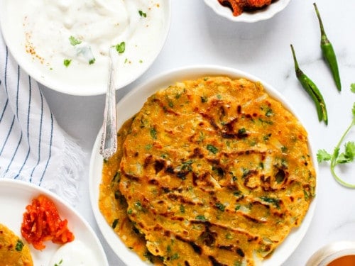 Thalipeeth served with yogurt, pickle and chutney