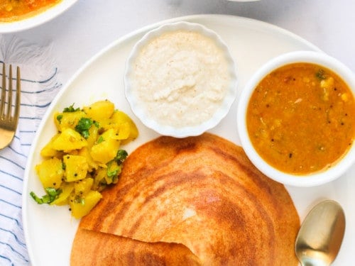 quinoa dosa served with chutney, potatoes and sambar