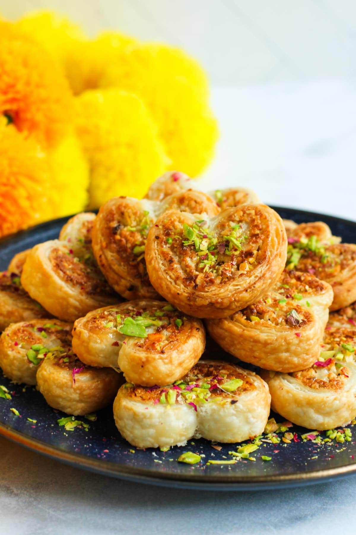 gujiya hearts garnished with thinly sliced pistachios.