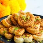 heart shaped gujiya bites garnished with pistachios.