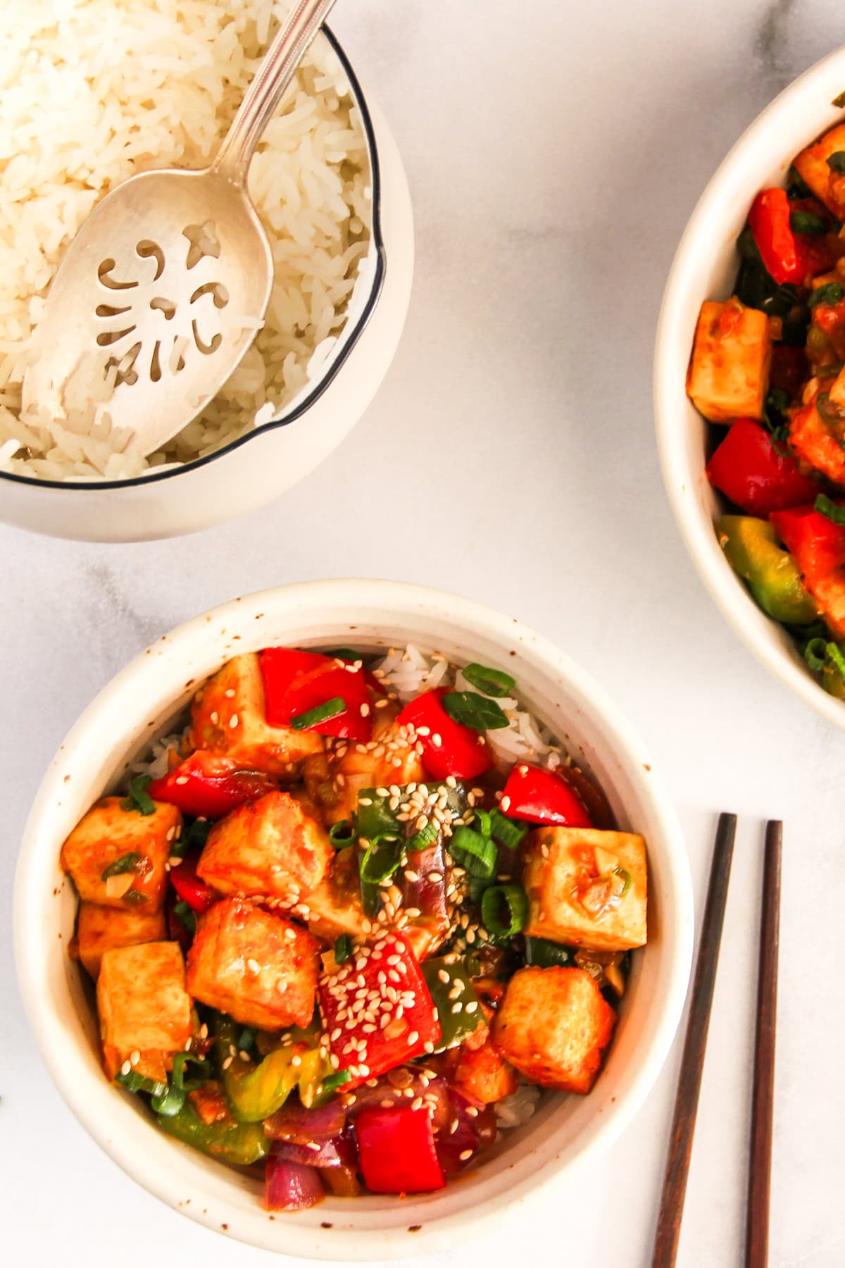 Chilli Tofu served over jasmine rice in a white bowl.